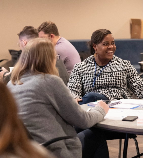 Two women seated around a table having a discussion and building healthy church culture